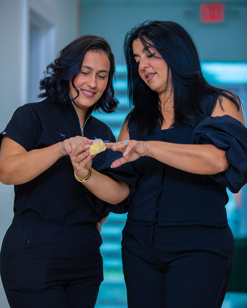 Dr. Farah and dental lab technician Jany reviewing a dental model for a smile design restoration at Deluxe Dental