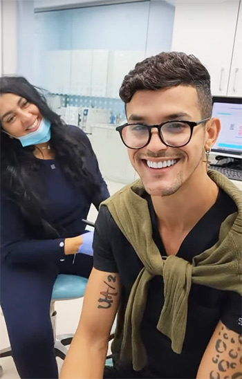 Patient proudly showing new smile alongside Dr. Farah at Deluxe Dental in Miami after cosmetic dental treatment.